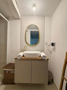 a bathroom with a tub and a round mirror at LOFT COSY - CENTRE HISTORIQUE climatisé in Revel
