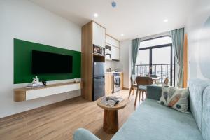 a living room with a blue couch and a green wall at The Harmony Red River Residence in Hanoi
