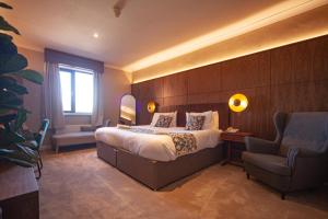 a hotel room with a bed and a chair at Highfield Hotel in Houghton le Spring