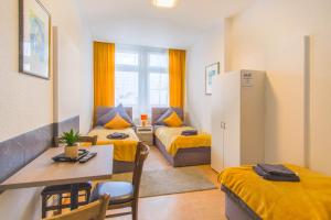 a small room with two beds and a table and chairs at Reform in Magdeburg