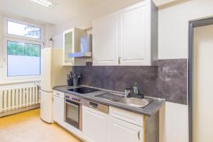 a kitchen with white cabinets and a sink and a refrigerator at Reform in Magdeburg +39 photos