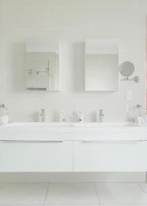 a white bathroom with a sink and a mirror at Naledi@53 Private Game Farm in Brits