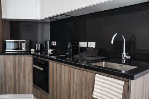 a kitchen with a sink and a microwave at 360 Luxury One Bedroom Suite in Nicosia