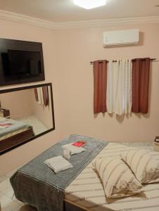 a room with a bed with a mirror and a mirror at Hotel Rebeka in São Paulo