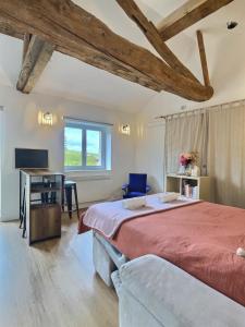 a bedroom with a large bed and a desk at Domaine Jubare in Fuissé