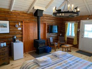 a bedroom with a bed and a wood stove at Au Pic de l'Aurore Motel-Chalets in Perce
