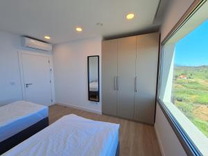 Un dormitorio con una cama y una ventana grande. en Quinta do Munot, en Raposeira do Logarinho