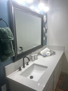 a bathroom with a sink and a large mirror at Entire Vacation home blocks to the Strip, ARTS Dist, & Main Street Sleeps up to 8 in Las Vegas