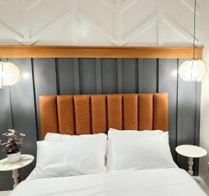 ein Bett mit einem orangefarbenen gepolsterten Kopfteil und weißen Kissen in der Unterkunft 2BR Penthouse SMDC Wind Residences Tagaytay in Kaybagal + 19 Fotos