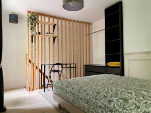 a bedroom with a bed and a table and a chair at Besançon: charmant duplex au pied de la citadelle in Besançon