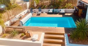 a swimming pool in a backyard with a wooden deck and a swimming pool at Villa exceptionnelle à Bayonne avec piscine et parking privée in Bayonne