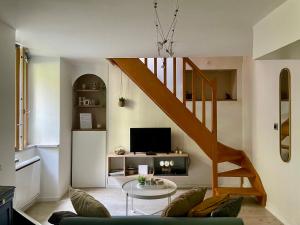 a living room with a staircase and a table at Besançon: charmant duplex au pied de la citadelle in Besançon +4 photos