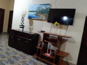 a living room with a dresser and a flat screen tv at Casa Maranata 