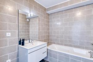 a bathroom with a tub and a sink and a bath tub at L'instant Zen - CNPE Bugey - Centre Meximieux in Meximieux