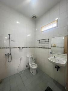 a bathroom with a toilet and a sink at Lemon Hotel Lembang in Bongkor 1