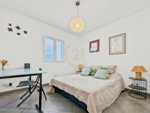 a white bedroom with a bed and a desk at La Parenthèse Corse in LʼÎle-Rousse