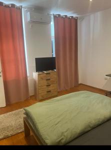 a bedroom with a bed and a tv and curtains at R&M old town sibiu in Sibiu