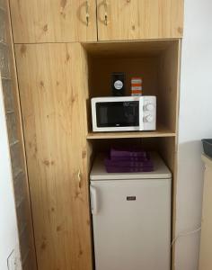 a microwave on top of a refrigerator in a kitchen at R&M old town sibiu in Sibiu