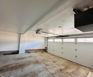 een lege garage met witte muren en een raam bij Cozy 2 bedroom suite Pet Friendly Heated Garage in Edmonton +15 foto's