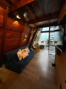 a living room with a blue couch in a house at DChalé in Japaratinga