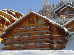 莱斯奥琉斯Appartement 3 pièces avec parking à Méribel - FR-1-411-187的一座大木结构建筑,有雪 更多7张照片