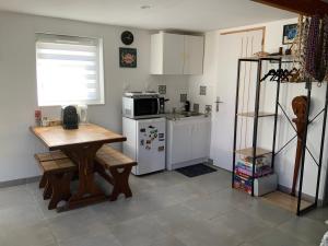 a kitchen with a table and a microwave and a refrigerator at Maison d’hôtes accès piscine in La Chaussée-Saint-Victor