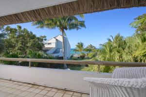 a balcony with a view of the ocean and palm trees at Villa Océana, 2 bedrooms, sea view and beach access in Cap Malheureux