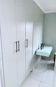 a white bathroom with white cabinets and a sink at Country Farm House in Delmas
