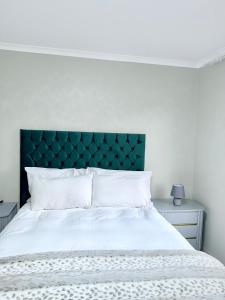 a white bed with a green headboard in a bedroom at Country Farm House in Delmas +17 photos
