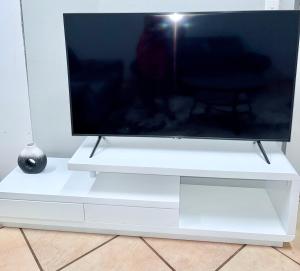 a white entertainment center with a large tv on it at Country Farm House in Delmas