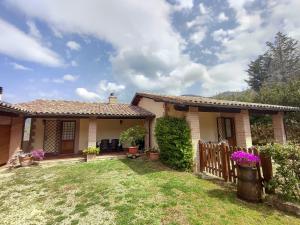 a small house with a fence in the yard at La Selvarella in Montecchio