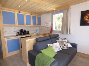 a living room with a couch and a kitchen at Charmant appartement 3 pièces à Méribel, au pied des pistes, avec terrasse exposée sud et proche du centre - FR-1-411-77 in Les Allues