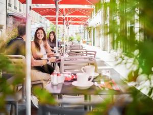 two women sitting at a table outside a restaurant at Mercure Lyon Centre Plaza République in Lyon