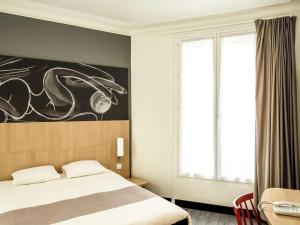 une chambre avec un lit et un tableau au mur dans l'établissement ibis Paris Grands Boulevards Opéra 9e, à Paris 52 autres photos
