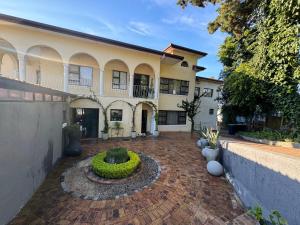 a large house with a brick courtyard in front of it at Welgemoed Villa in Bellville