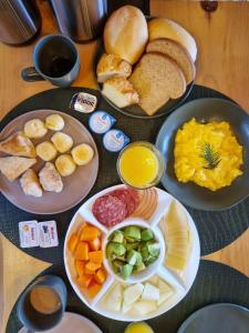 a table with plates of food on a table at Parador dos Canyons in Cambará