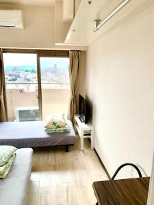 ein kleines Zimmer mit einem Bett und einem Fenster in der Unterkunft Nagoya Station is nearby, convenient for shopping in Nagoya