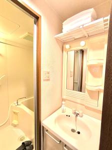 ein Badezimmer mit Waschbecken und Spiegel in der Unterkunft Nagoya Station is nearby, convenient for shopping in Nagoya