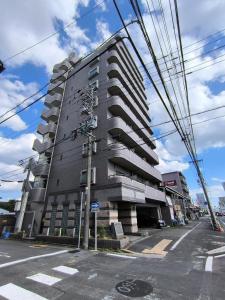 ein hohes Gebäude an der Ecke einer Straße in der Unterkunft Nagoya Station is nearby, convenient for shopping in Nagoya