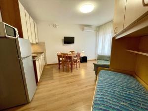 a kitchen and dining room with a table and a refrigerator at Functional studio by the beach-Beahost in Porto Santa Margherita di Caorle