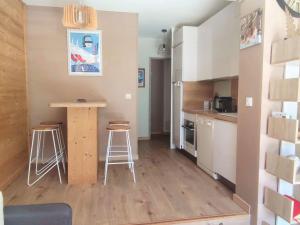イゾラ 2000にあるBel Appartement Rénové au Pied des Pistes à Isola 2000 - FR-1-292-132の部屋にカウンターとスツールがあるキッチン