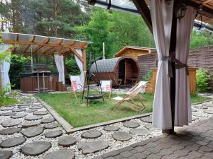 a patio with a grill and chairs in a yard at Agroturystyka Leśna Malinka in Celejów +22 photos