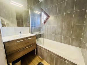 a bathroom with a tub and a sink and a bath tubermottermott at Appartement cosy 2 pièces, 8 couchages à Vars Les Claux - FR-1-330B-223 in Vars