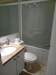 a bathroom with a toilet and a sink and a mirror at Borde Costero in Valparaíso
