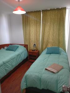 a bedroom with two twin beds and a window at Borde Costero in Valparaíso