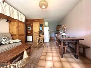 un salon avec une table et une cuisine dans l'établissement Charmant T2 cabine avec jardin et parking près de Serre Chevalier - FR-1-330F-243, au Monêtier-les-Bains