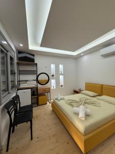 ヒマラにあるJofri Roomsの大きなベッドと机のある寝室