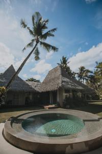 a resort with a swimming pool in front of a building at Mémé Villa Siargao in General Luna