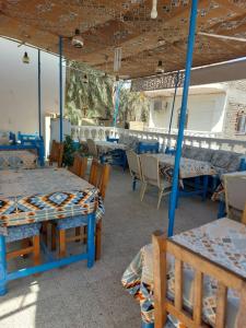 a dining room with blue tables and chairs at Blue Sky Apartments & Restaurant in Luxor