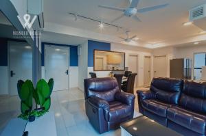un salon avec un canapé en cuir et une table dans l'établissement 6pax Family-Friendly 3BR Stay in Kajang, à Kajang